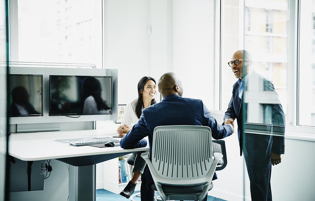 Business professionals shaking hands in office.