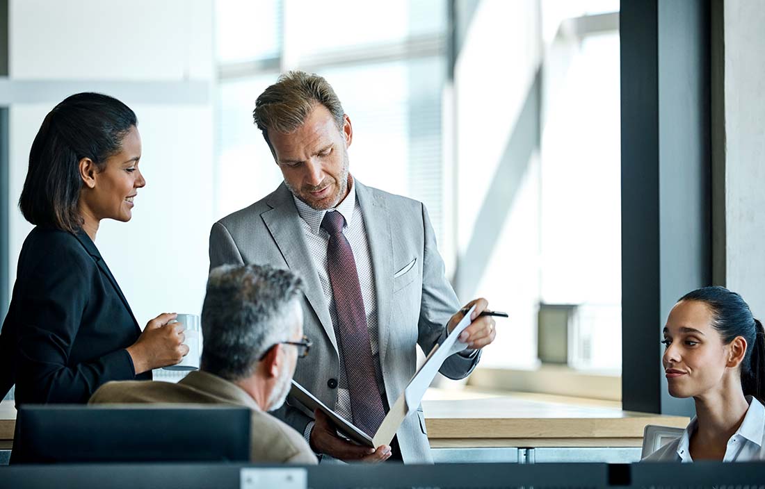 Group of business professionals looking at a report.