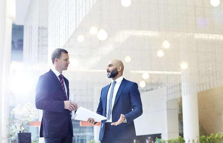 Business professional discussing state and local tax updates while standing in a lobby.