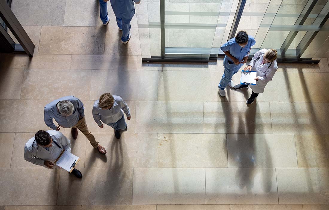 Aerial shot of people walking into the lobby of a hospital.