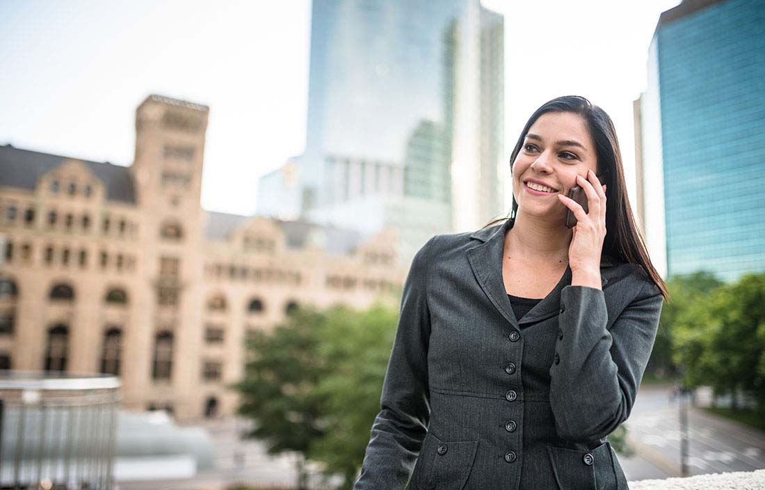 Business professional talking on cell phone while walking through city.