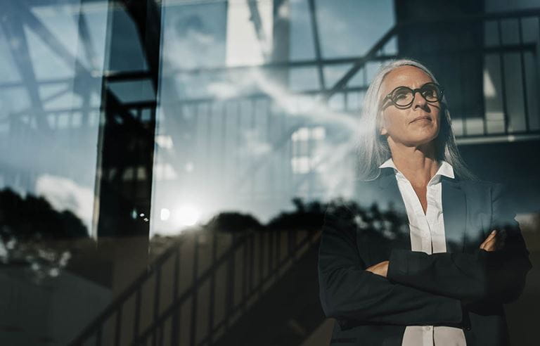 Business professional standing next to a glass window