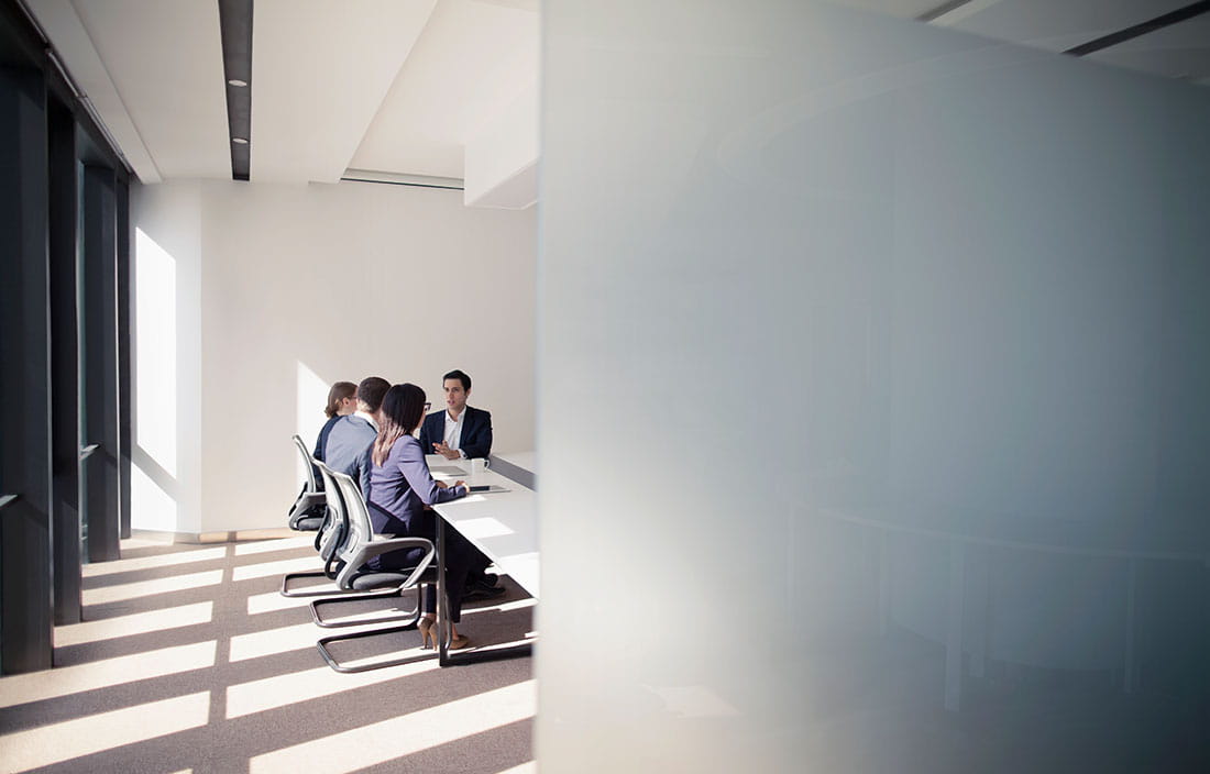 Business professionals in modern conference room discussing considerations for nearshoring.