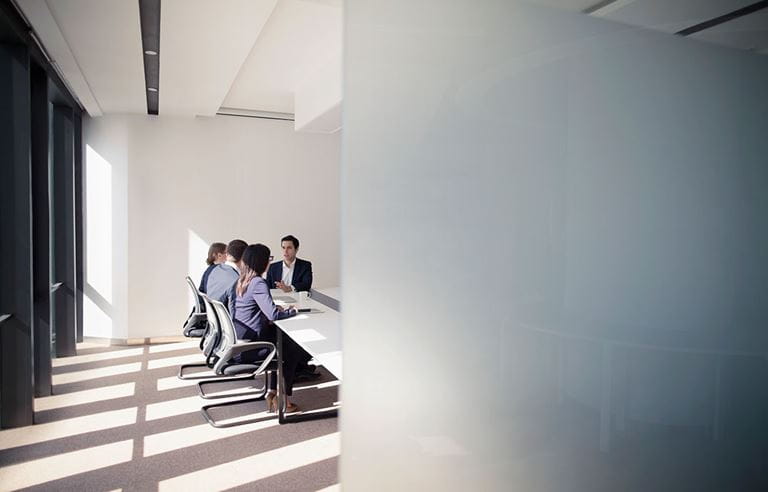 Business professionals in modern conference room discussing considerations for nearshoring.