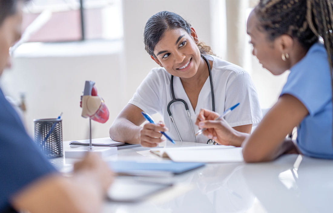 Healthcare staff collaborate and talk on strategy before surgery.