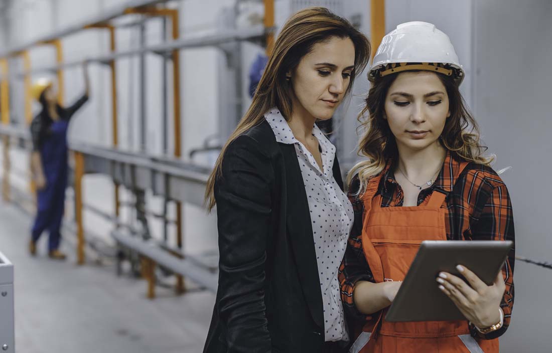 Manufacturing professionals looking at a tablet computer.