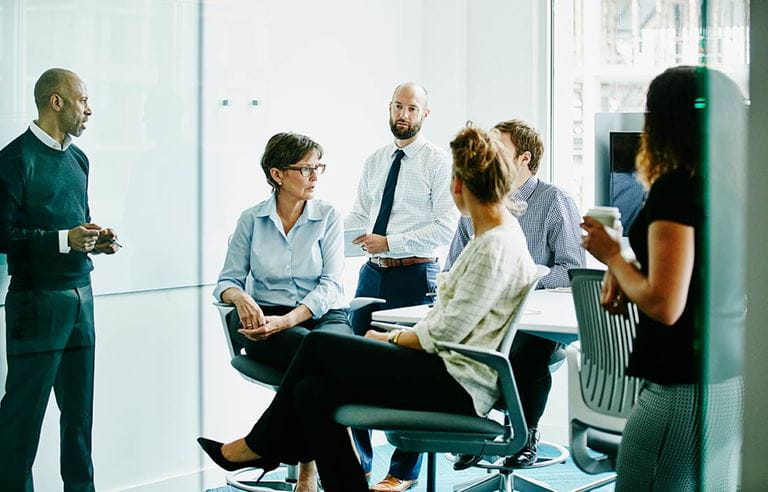 Business professionals in modern conference room discussing contingent consideration.