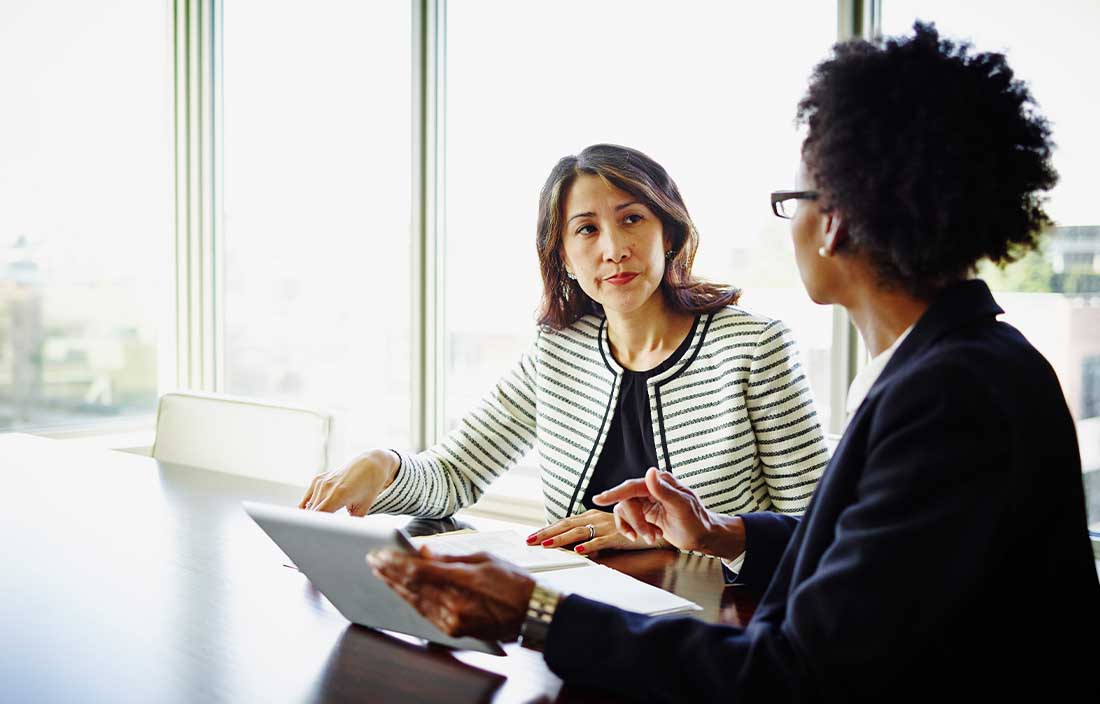 Two franchisees in a conference room discussing questions to ask before a PE partnership.