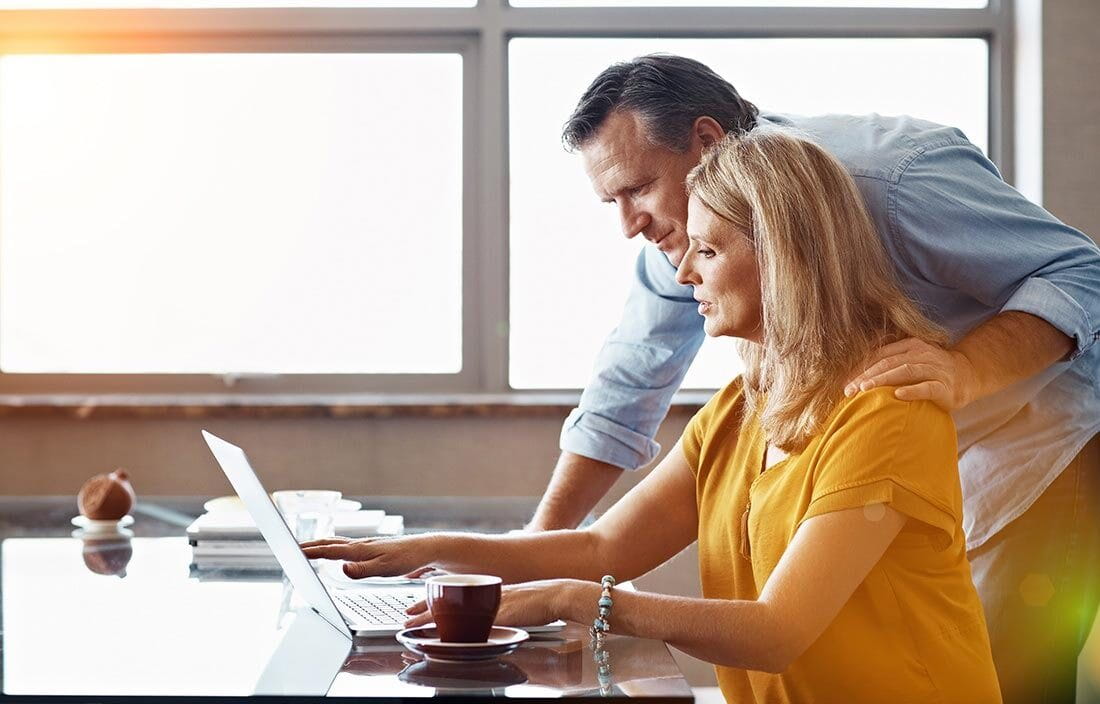 A couple reviewing life insurance annuities on their laptop computer