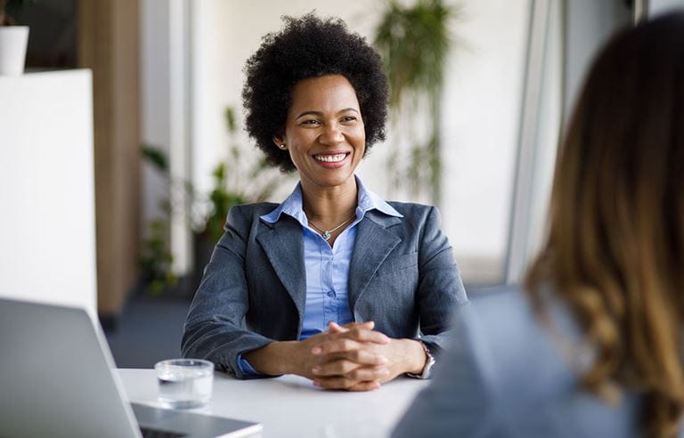 Financial professional sitting at their desk and discussing CECL adoption.