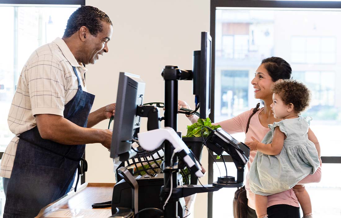 Parent and child using a gift card to check out of a retail store.