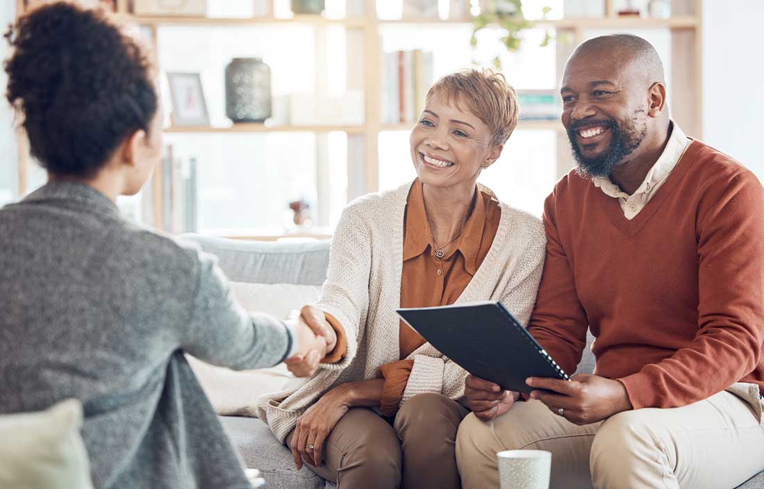 Two wealthy individuals meeting with a financial advisor to learn about the best financial strategies.