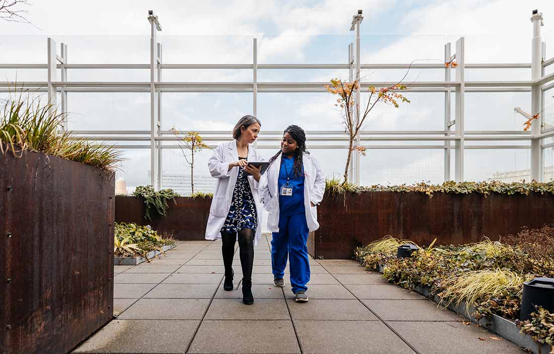 Two doctors walking together outside.