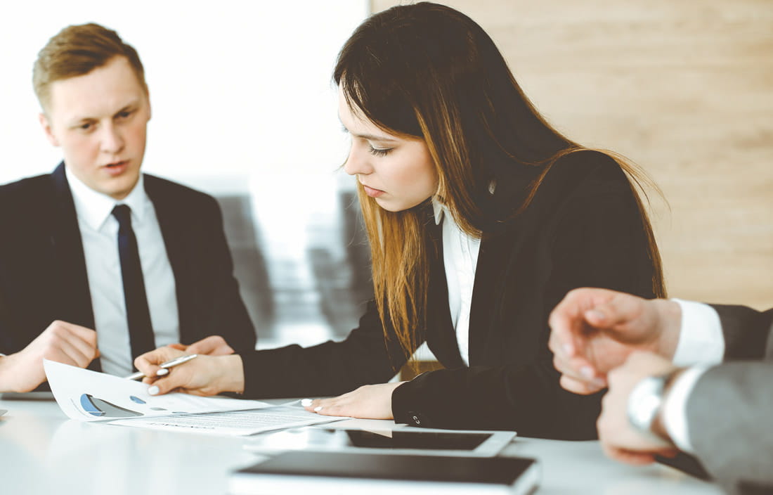 Business executives in a meeting discussing how to optimize value during restructuring.