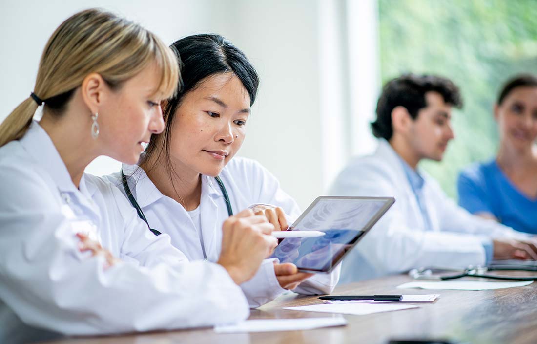 Medical professionals reviewing information on their tablet computer.