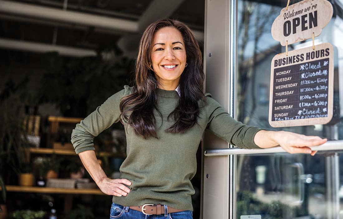 Franchise owner smiling and standing at their doorfront.