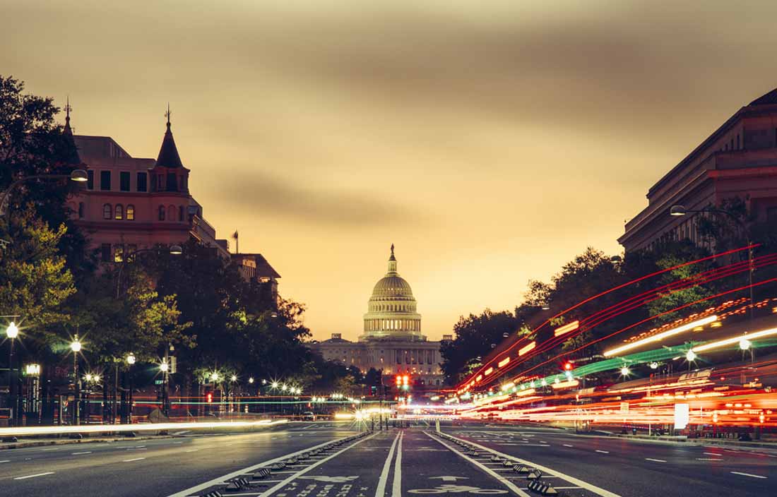 View of a street in the evening with the United States Capitol building in the distance