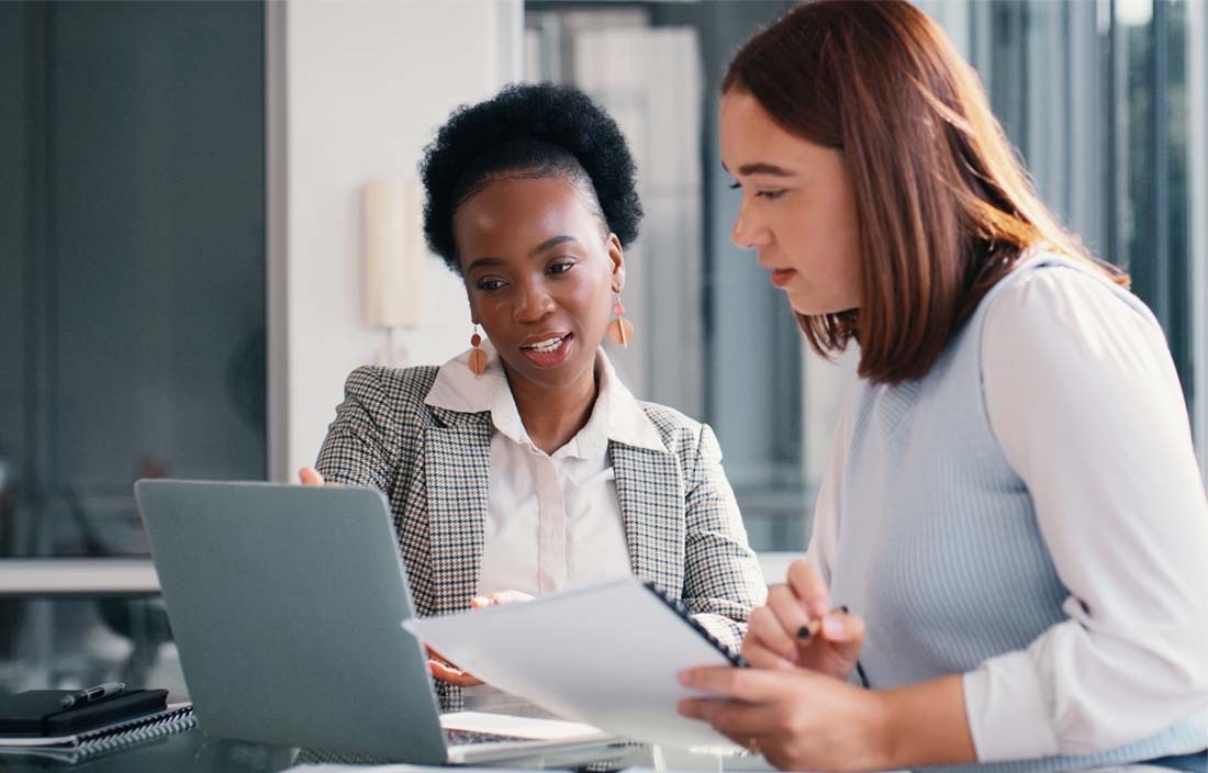 Financial professionals reviewing compliance updates on their laptop computer.