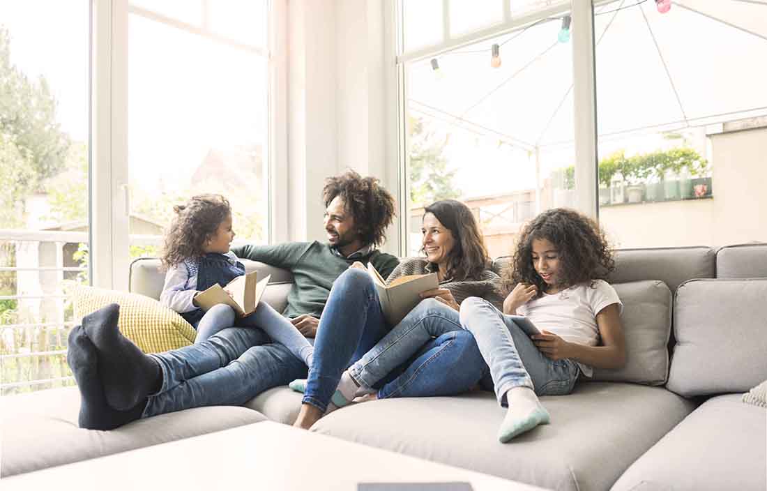 Family on a couch smiling and chatting.