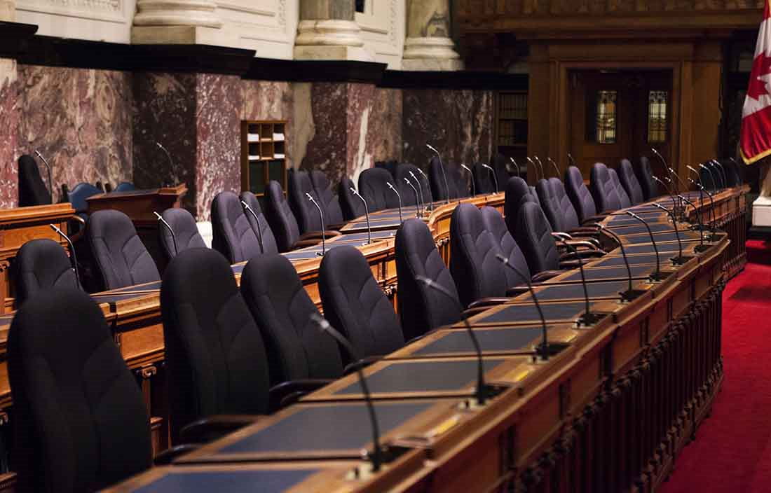 View of empty council chamber seats in a government building.