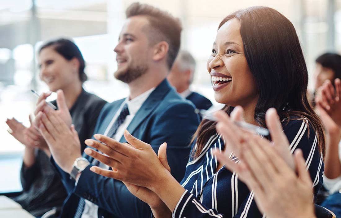 Group of financial professionals clapping and smiling.