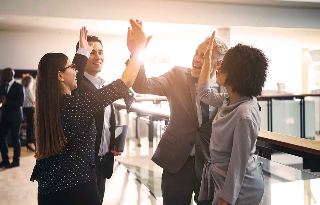 Group of financial advisors high-fiving and celebrating.