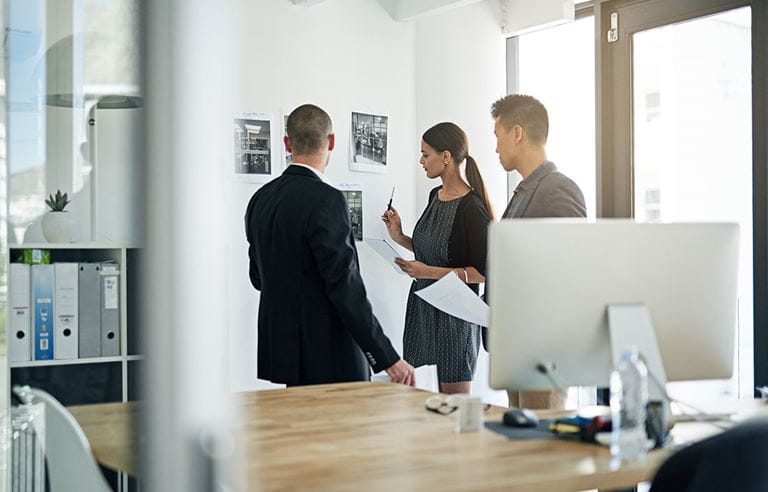 Group of business professionals discussing downward attribution rules.