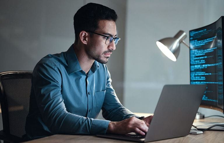 A business professional working on a laptop at their desk