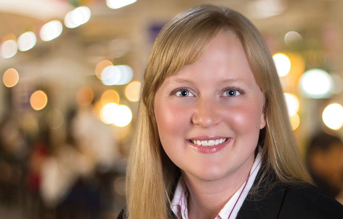 Professional photo of Sadie Mayle in front of brightly colored, blurred background.