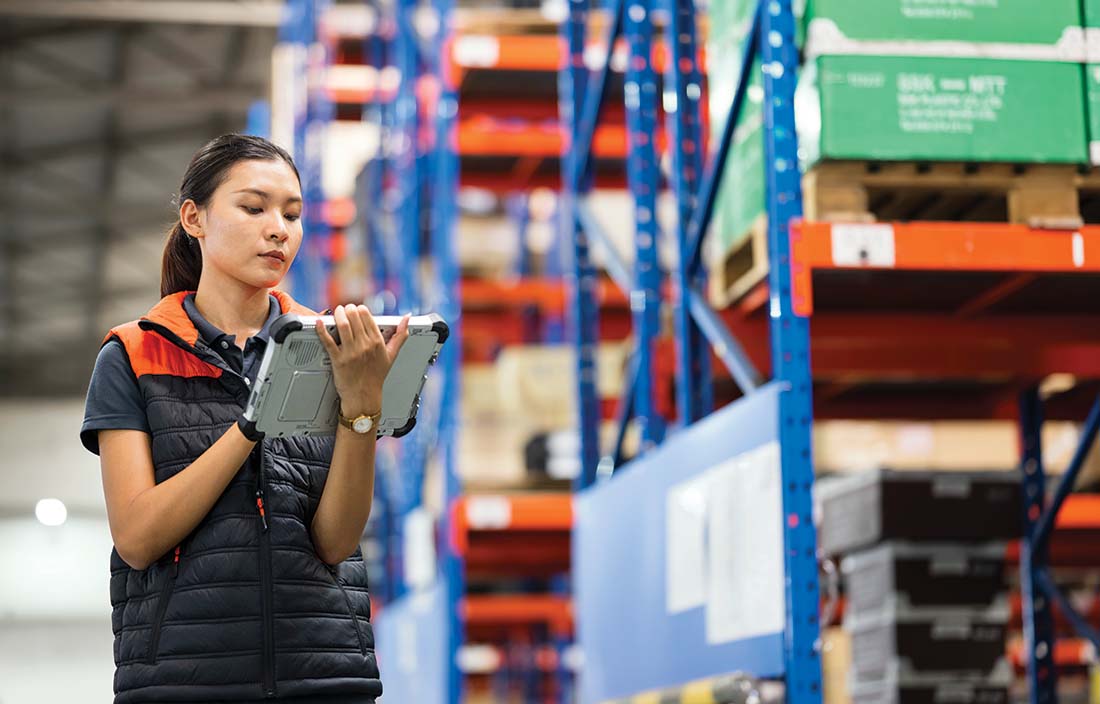 Person checking inventory on their tablet computer in a factory.