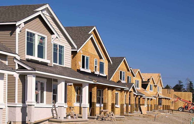 Senior living development of repositioned homes, with one home complete and sold and the others along the street under construction