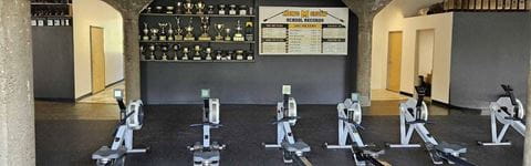 University of Michigan Rowing Association new location's interior showing rowing machines and awards