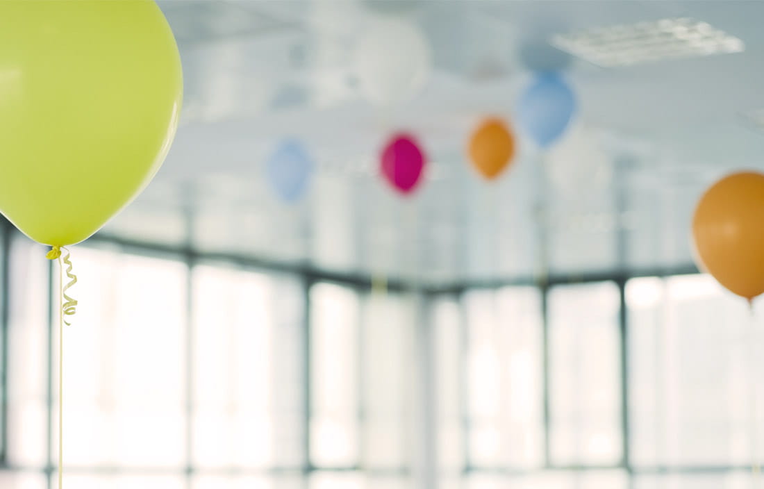 Colorful helium ballons on an office ceiling