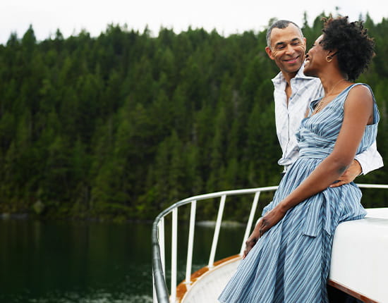 Couple smiling at one another while on a boat.