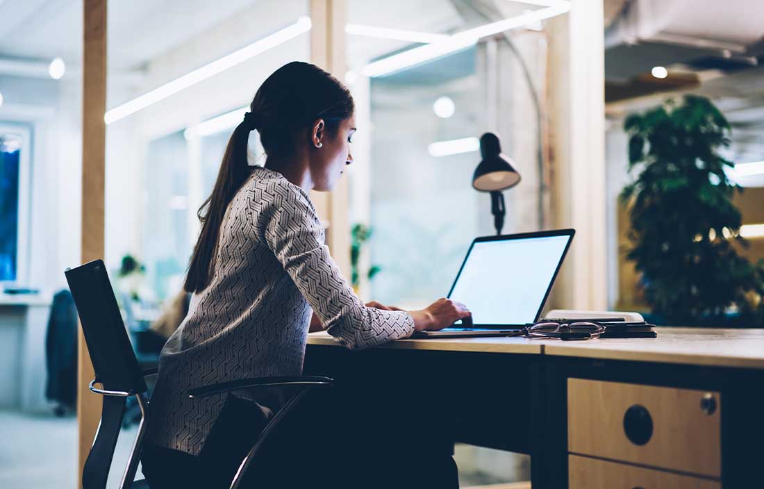 Person sitting at desk looking at a computer with consumer sentiment data