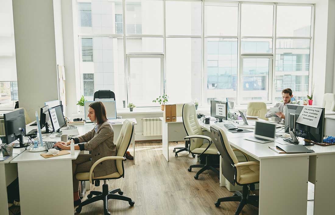 Employees in an office, while so desk stations are empty