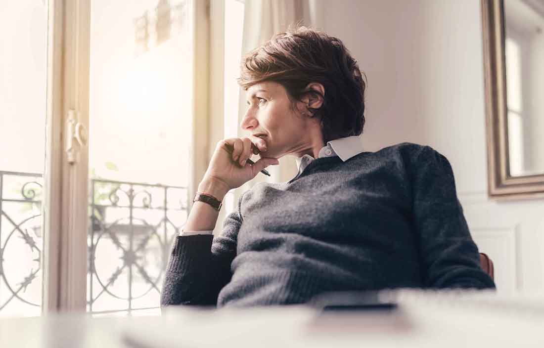 Woman looking out window thinking