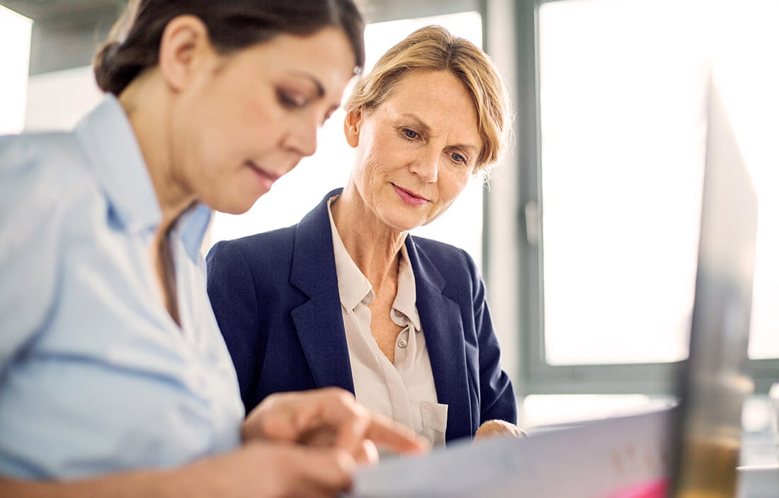 Two women working together on a laptop