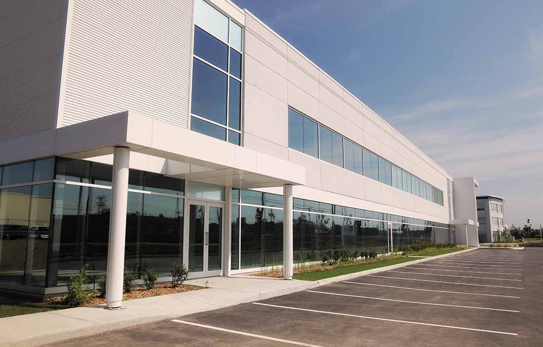 View of an office building with an empty parking lot in the morning.