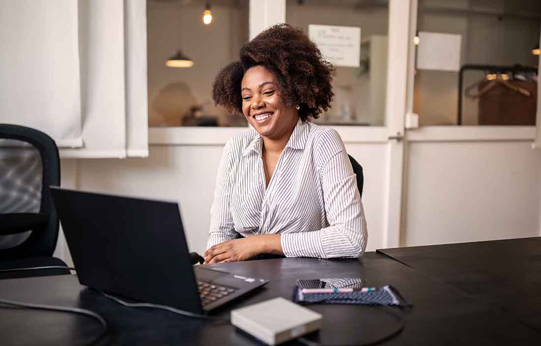 Businesswoman sitting in front of laptop computer at a desk.