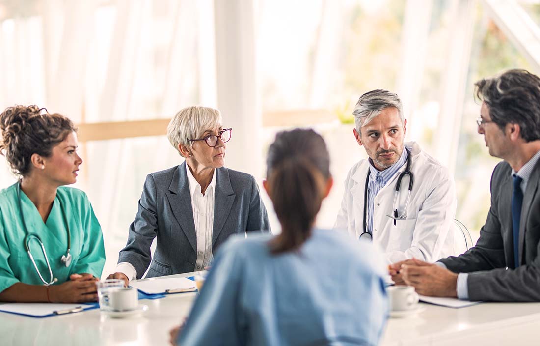 A group of doctors and colleagues having a meeting in a board room.